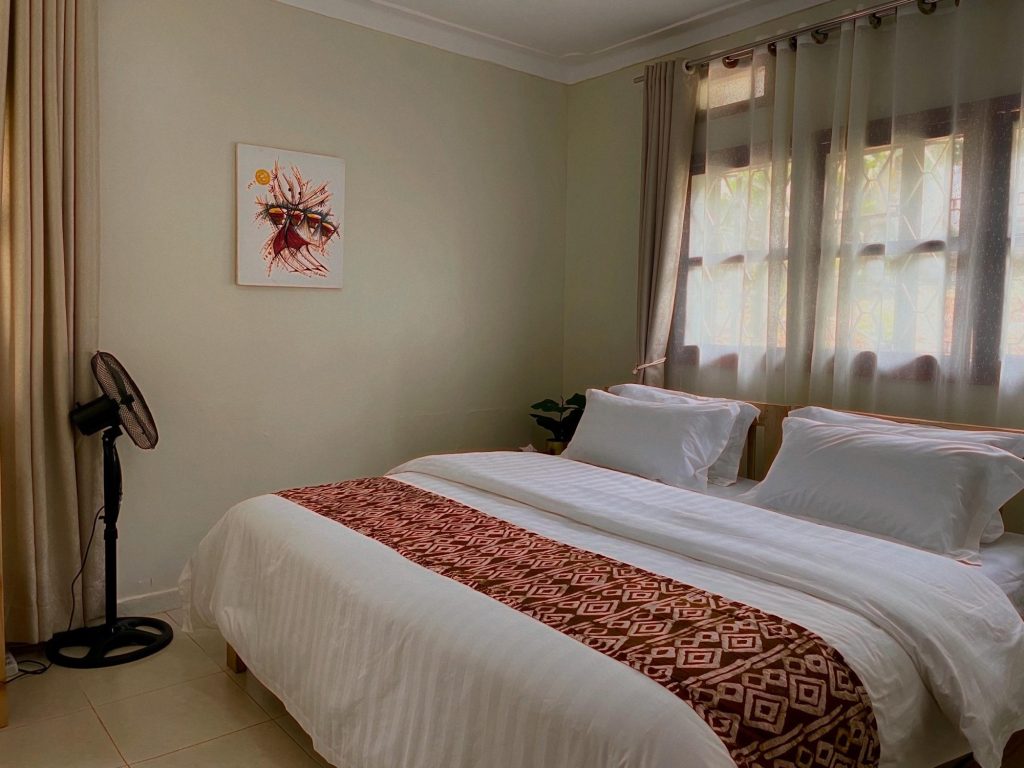 Double bedroom with woven runner and African art, JOSIRE Residence