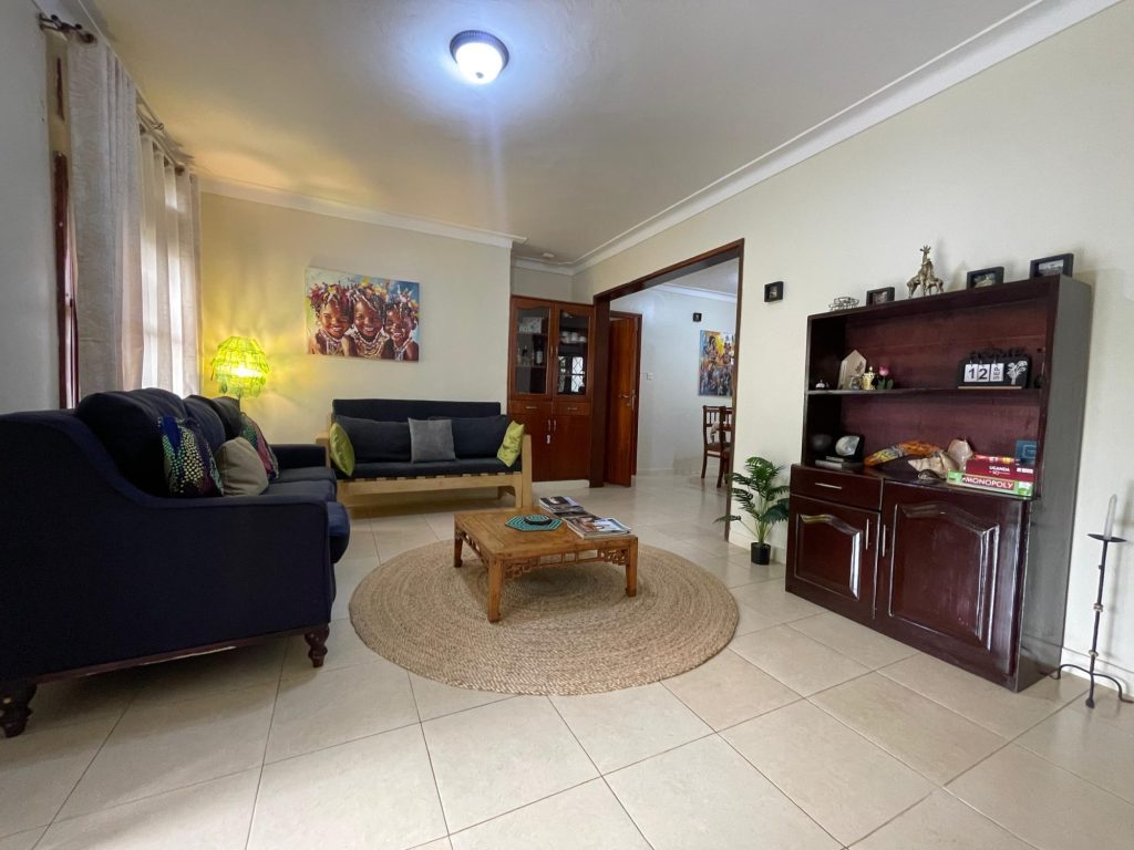 Comfortable guest lounge with sofas and African artwork, JOSIRE Residence